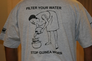 The text in this t-shirt from south Sudan 'Filter your water, Stop Guinea Worm' complements the image of a woman filtering her water. The clay pots she uses are similar to those used in the region, and a low-literate person would be able to understand the message, as well.